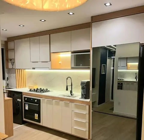 Cozinha planejada branca e madeira com geladeira espelhada e luz de LED